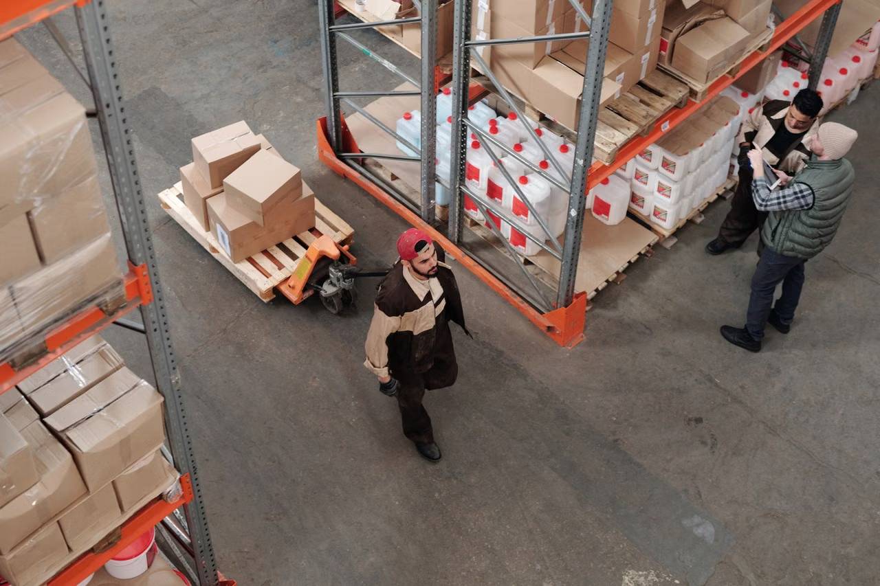 Warehouse team organizing inventory among pallets and stock.